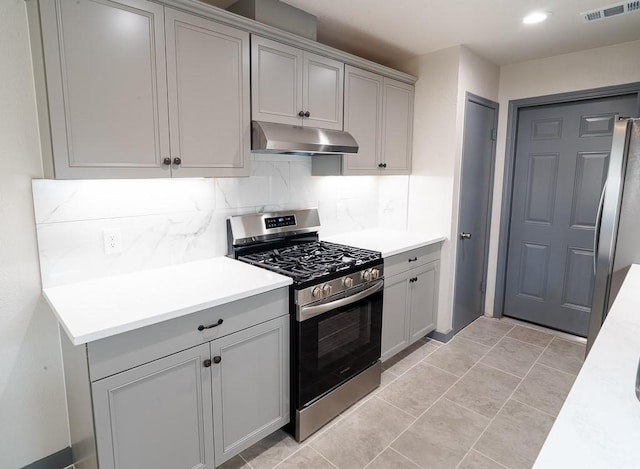 kitchen featuring stainless steel appliances, tasteful backsplash, gray cabinetry, and light tile patterned flooring