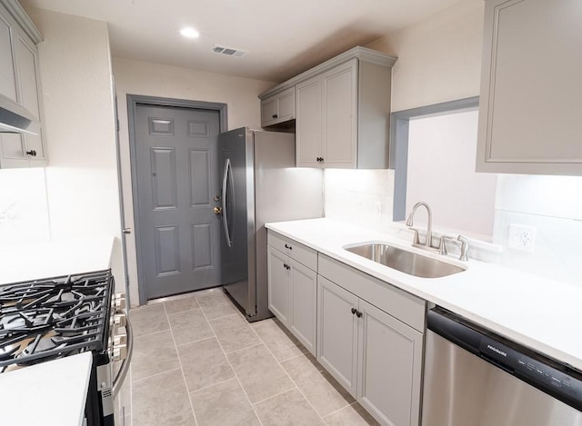 kitchen featuring gray cabinetry, sink, wall chimney exhaust hood, appliances with stainless steel finishes, and light tile patterned flooring