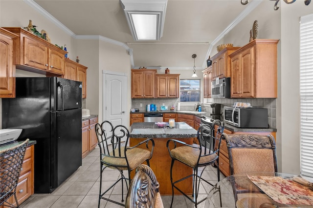 kitchen featuring stainless steel appliances, a kitchen island, tasteful backsplash, crown molding, and light tile patterned flooring