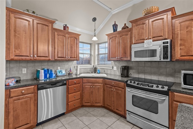 kitchen with lofted ceiling, crown molding, sink, decorative backsplash, and stainless steel appliances