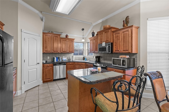 kitchen featuring black appliances, light tile patterned flooring, tasteful backsplash, and vaulted ceiling