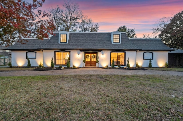 view of front of home featuring french doors and a lawn