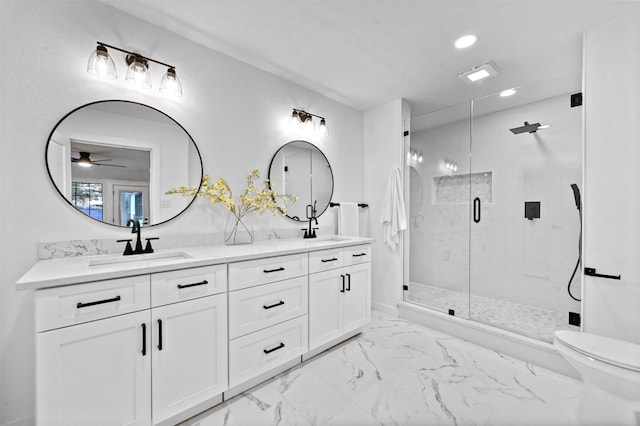 bathroom with vanity, toilet, ceiling fan, and a shower with shower door