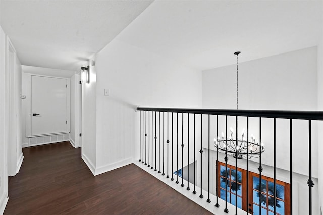 hallway featuring an inviting chandelier and dark hardwood / wood-style flooring