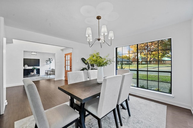 dining room with dark hardwood / wood-style floors and a notable chandelier