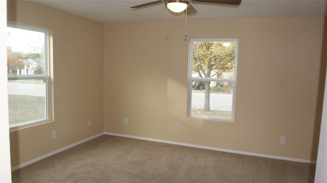 carpeted spare room with ceiling fan