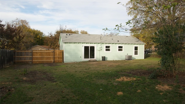 back of property featuring a lawn and central air condition unit