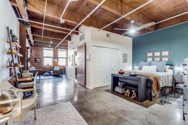 bedroom featuring wooden ceiling, brick wall, a high ceiling, concrete floors, and rail lighting