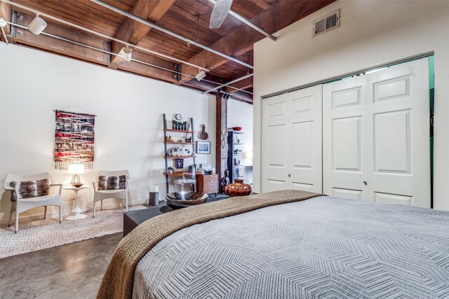 bedroom with a closet, beam ceiling, ceiling fan, and wooden ceiling