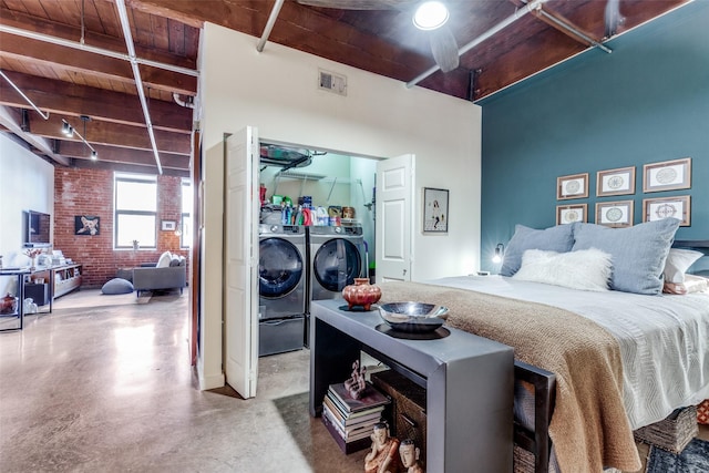 bedroom with brick wall, wooden ceiling, washer and clothes dryer, and beam ceiling