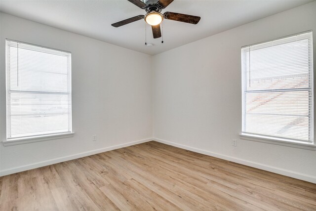 empty room with ceiling fan, light hardwood / wood-style flooring, and a healthy amount of sunlight