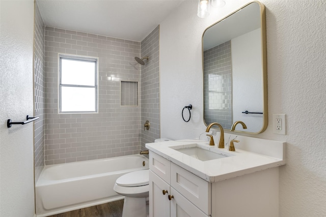 full bathroom featuring hardwood / wood-style flooring, vanity, toilet, and tiled shower / bath combo