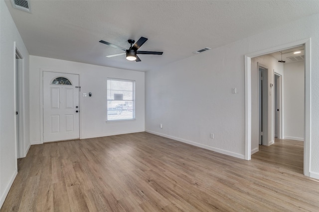 interior space featuring ceiling fan, light hardwood / wood-style floors, and a textured ceiling