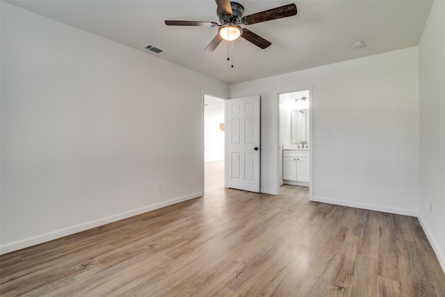 unfurnished bedroom featuring connected bathroom, light hardwood / wood-style floors, and ceiling fan