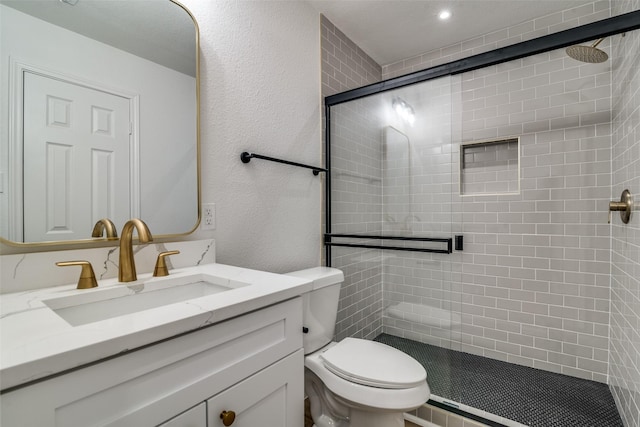 bathroom featuring vanity, toilet, and a shower with shower door