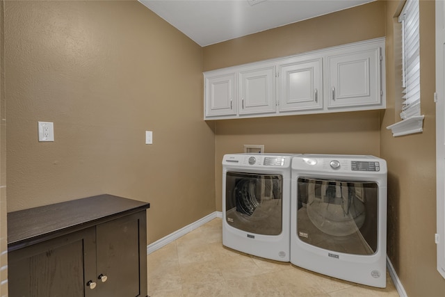 clothes washing area featuring cabinets, separate washer and dryer, and light tile patterned floors