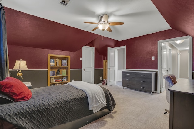 bedroom with light colored carpet, vaulted ceiling, and ceiling fan