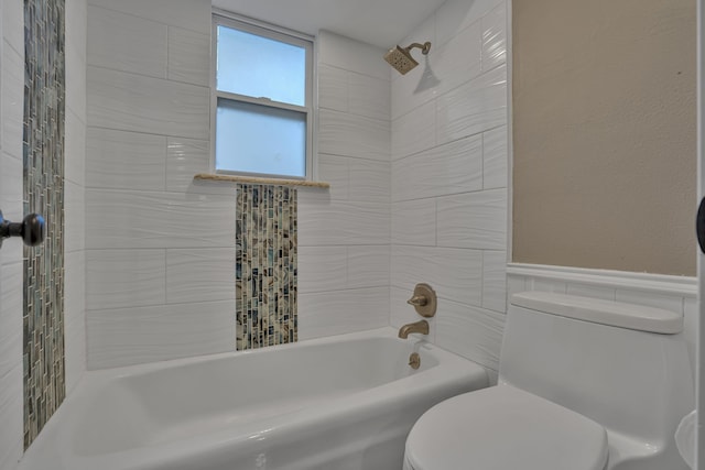 bathroom featuring toilet, tile walls, and tiled shower / bath