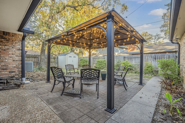 view of patio / terrace featuring a gazebo, cooling unit, and a shed