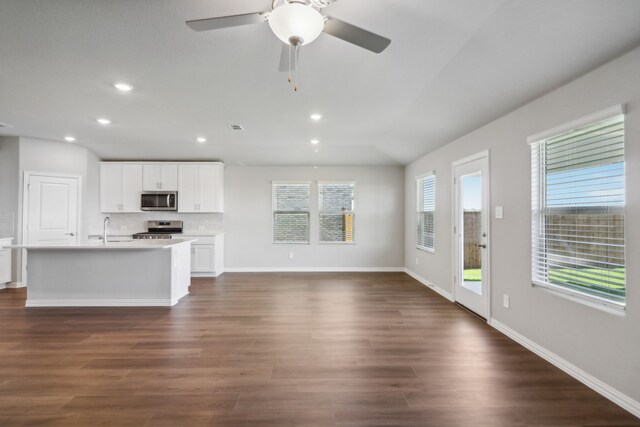 living room with ceiling fan, plenty of natural light, and hardwood / wood-style flooring