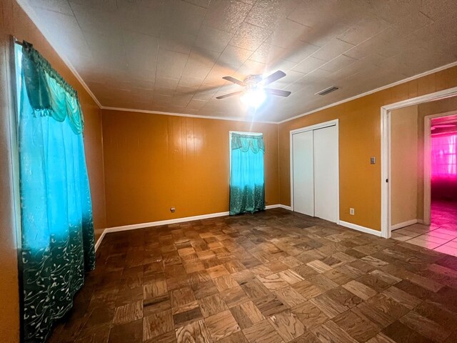 unfurnished bedroom with ceiling fan, crown molding, and parquet flooring