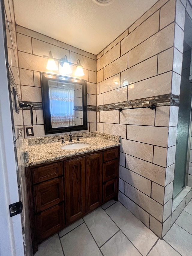 bathroom featuring vanity and tile walls