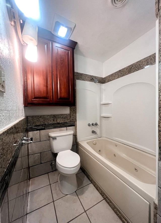 bathroom featuring tile patterned floors, toilet, tile walls, and tub / shower combination