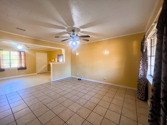 tiled empty room with ceiling fan and ornamental molding