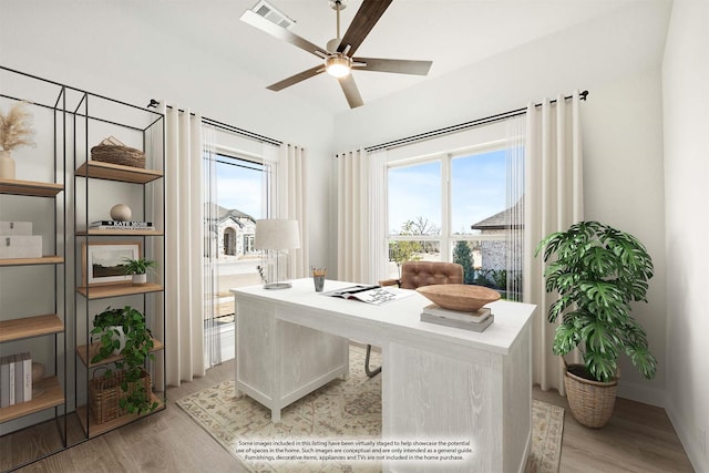 home office with light wood-type flooring and ceiling fan