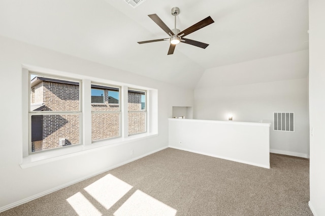 empty room with ceiling fan, vaulted ceiling, and carpet