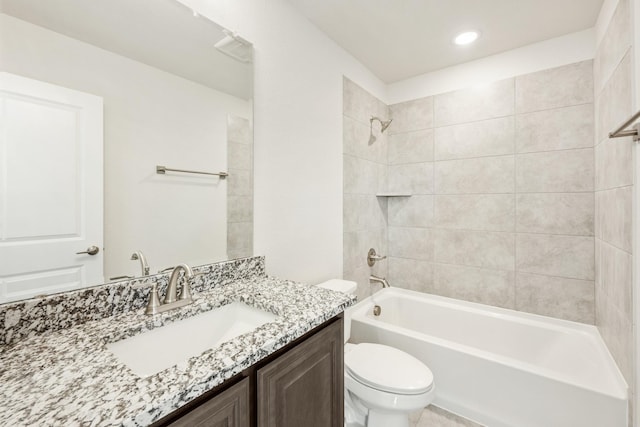 full bathroom featuring tiled shower / bath combo, vanity, and toilet