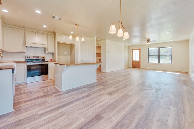 kitchen featuring ceiling fan, electric stove, hanging light fixtures, and light hardwood / wood-style flooring