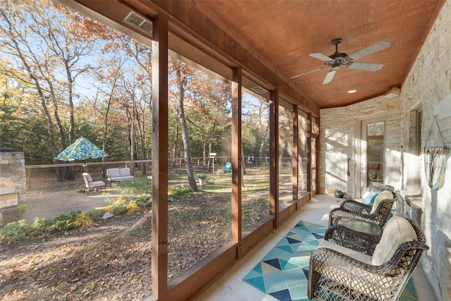 sunroom / solarium featuring ceiling fan and wood ceiling