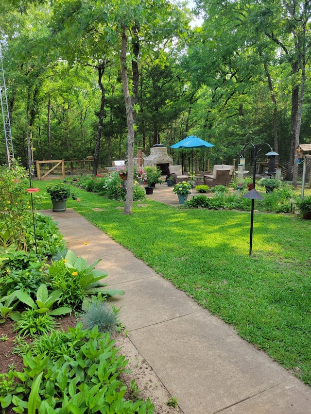 view of property's community featuring a yard and a patio area