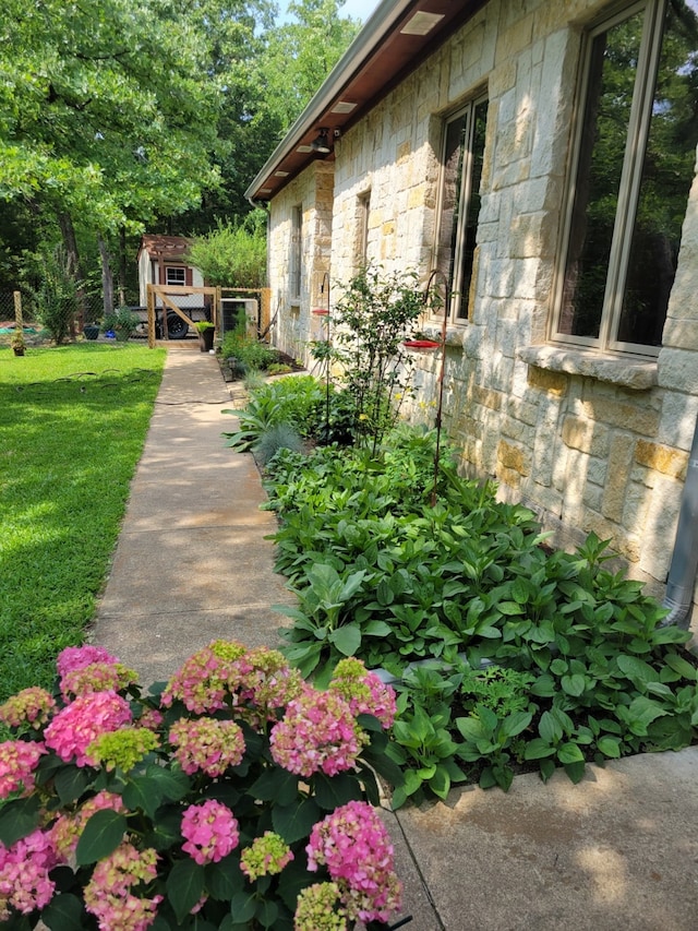 view of home's exterior with a lawn and a storage unit