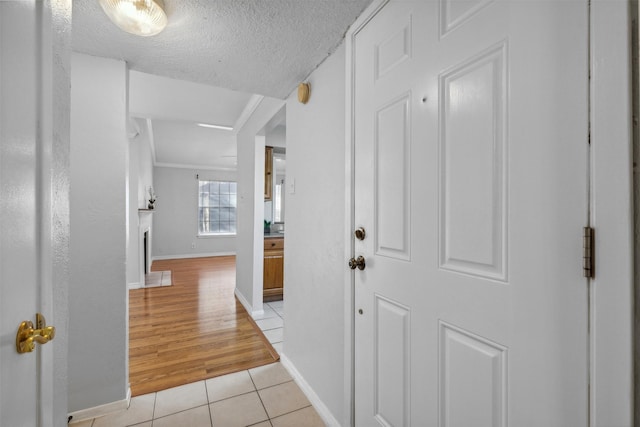 corridor with light tile patterned floors and a textured ceiling