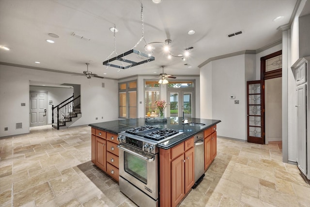 kitchen featuring sink, stainless steel range with gas cooktop, ornamental molding, and a kitchen island