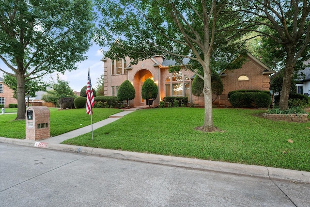 view of front of house featuring brick siding and a front yard