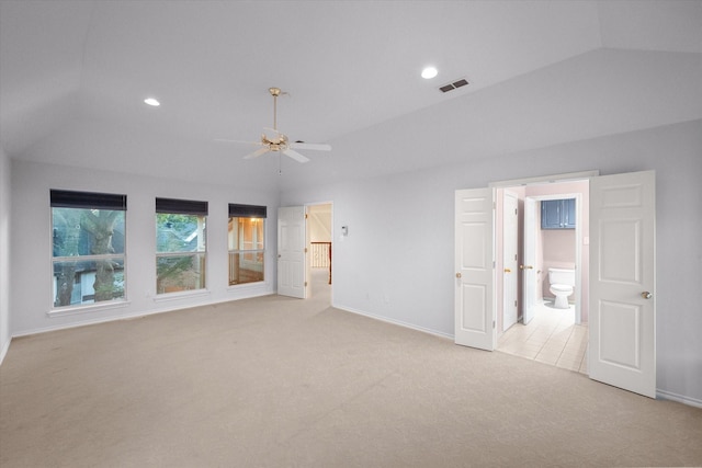 unfurnished bedroom featuring baseboards, visible vents, light colored carpet, lofted ceiling, and connected bathroom