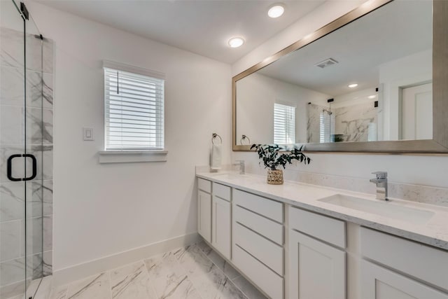 bathroom with a wealth of natural light, a shower with door, and vanity