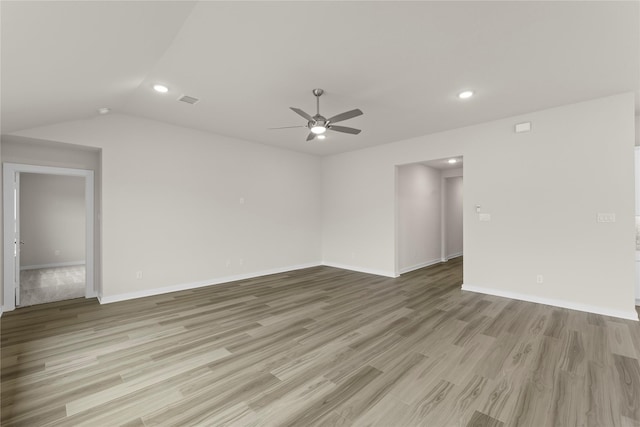 empty room with visible vents, vaulted ceiling, a ceiling fan, and light wood-style floors