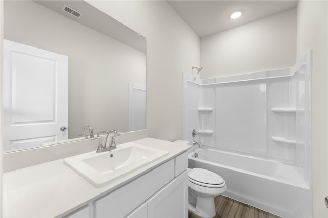 bathroom featuring toilet, wood finished floors, bathing tub / shower combination, vanity, and visible vents