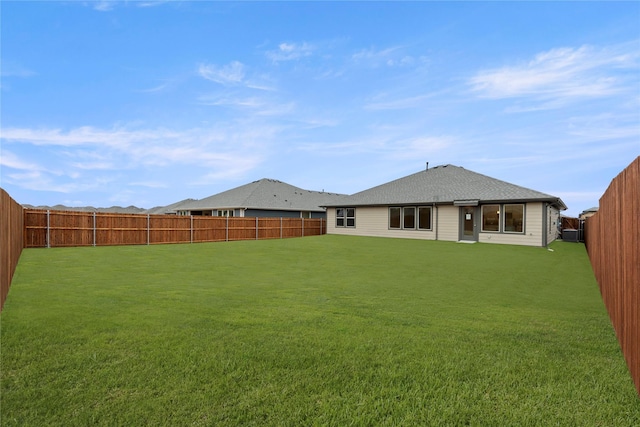 back of house featuring a fenced backyard and a yard