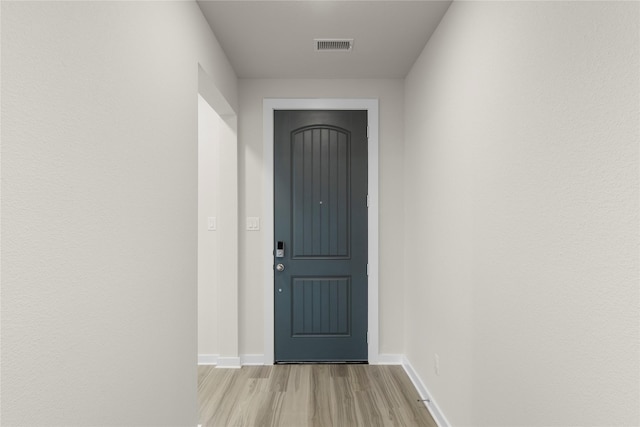 doorway to outside featuring light wood finished floors, visible vents, and baseboards