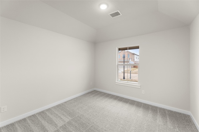 unfurnished room featuring carpet, visible vents, lofted ceiling, and baseboards