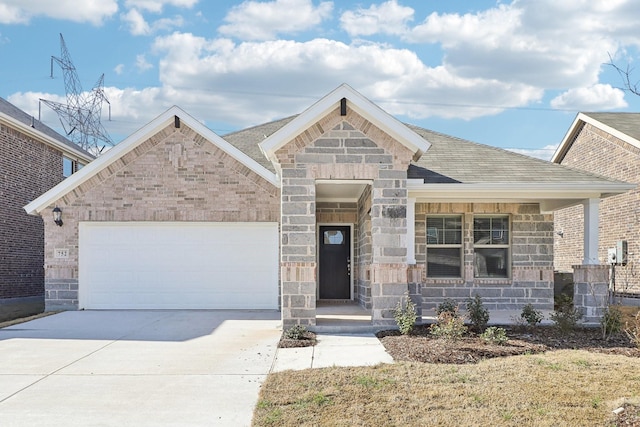 view of front of house featuring concrete driveway, a garage, stone siding, and roof with shingles