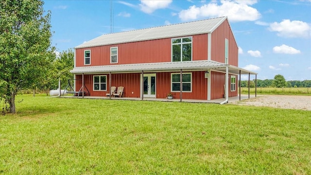 back of house with french doors and a lawn