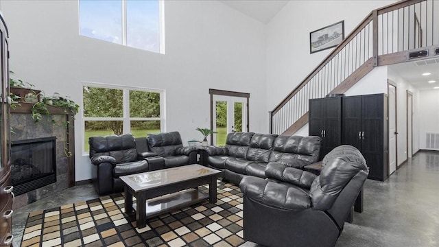 living room featuring a fireplace and a towering ceiling