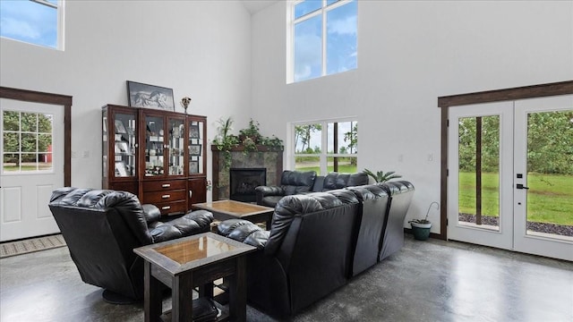 living room featuring a fireplace, french doors, and a towering ceiling