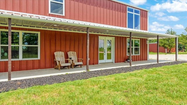 back of property with french doors and a lawn